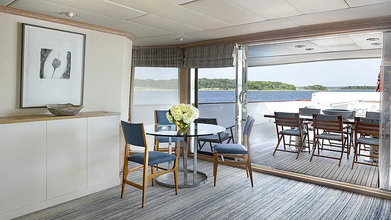 a room with a table chairs and a window aboard NATALIA V Yacht for Sale