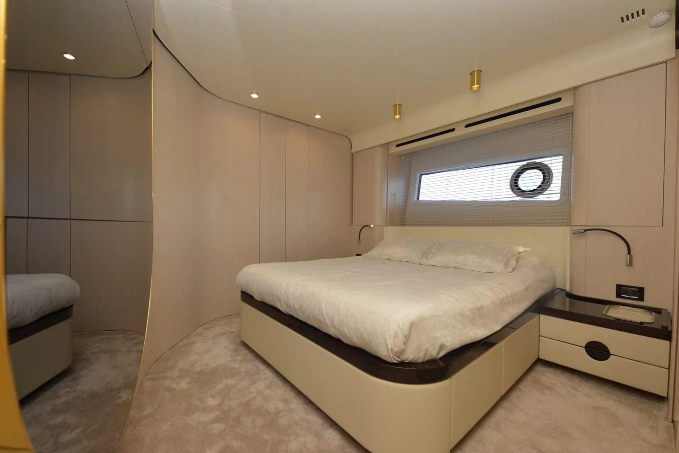 a bedroom with a bed and a window aboard ANANDA Yacht for Sale