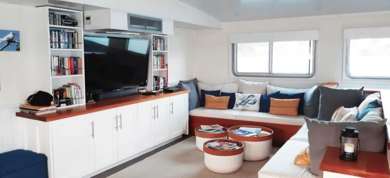 a living room with a couch and a tv aboard BASILISK Yacht for Sale