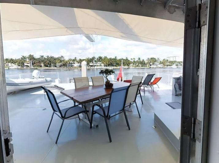 a table and chairs on a balcony aboard BASILISK Yacht for Sale