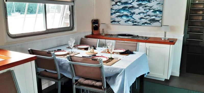 a table with plates and glasses on it aboard BASILISK Yacht for Sale