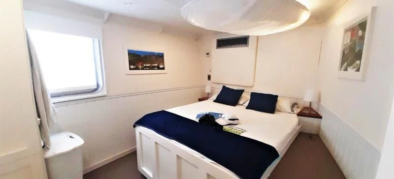 a bedroom with a bed and a desk aboard BASILISK Yacht for Sale