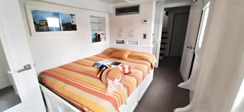 a bedroom with a bed and a guitar aboard BASILISK Yacht for Sale