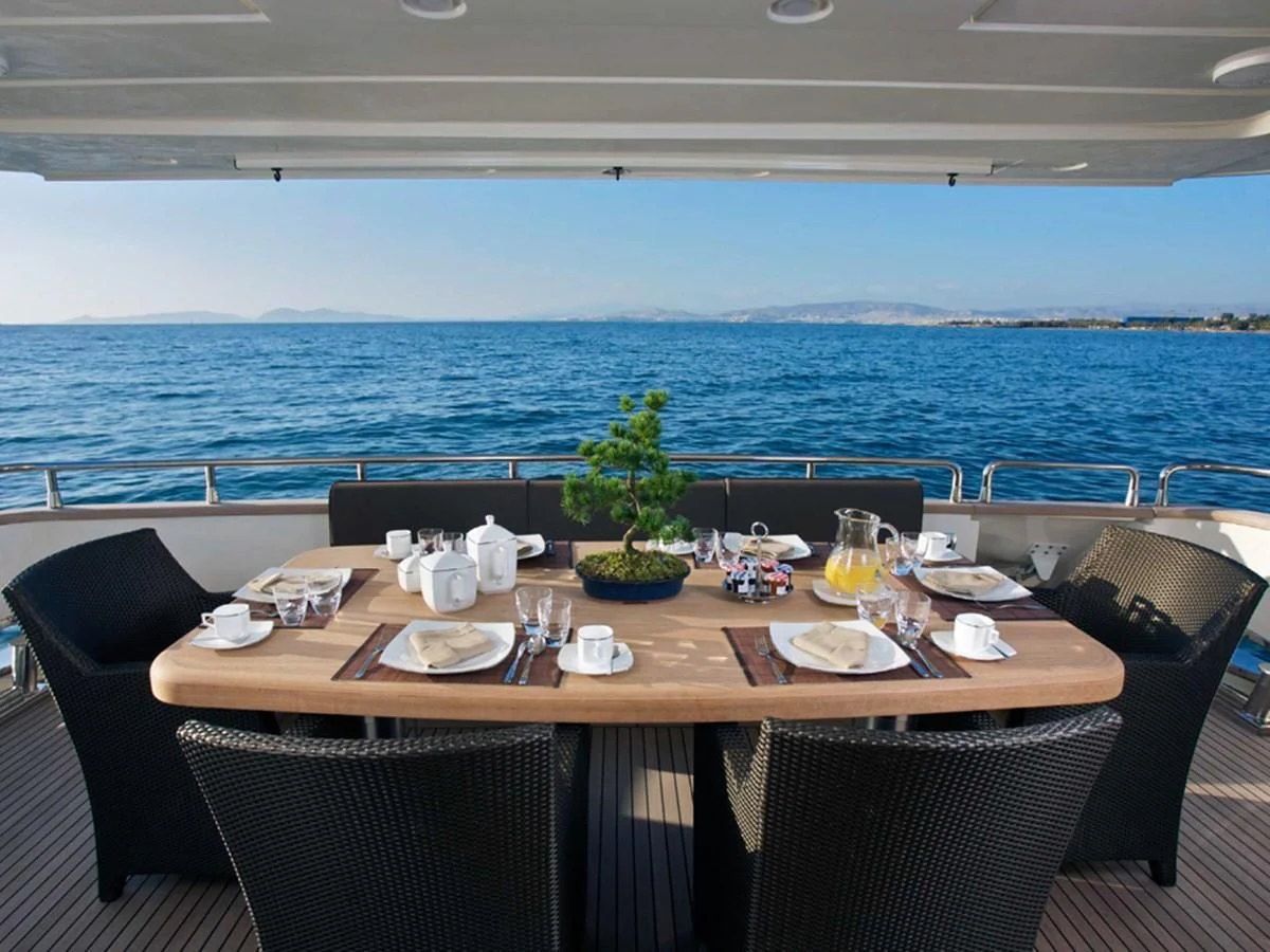 a table set with chairs and a plant on the table aboard HABANO Yacht for Sale