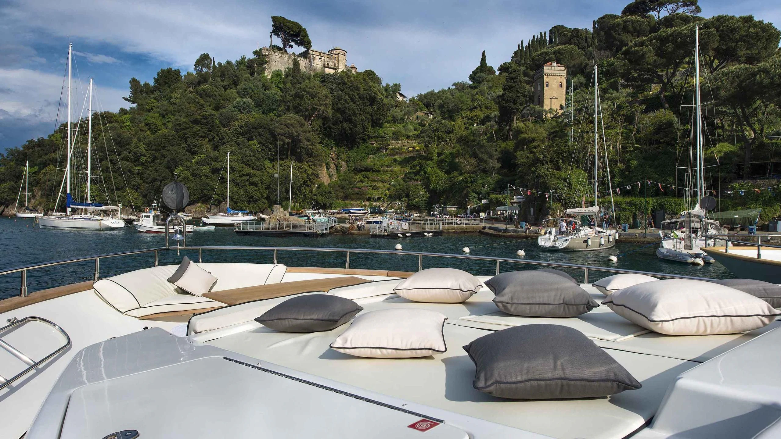 a marina with boats and a castle in the background aboard LUMINOUS Yacht for Sale