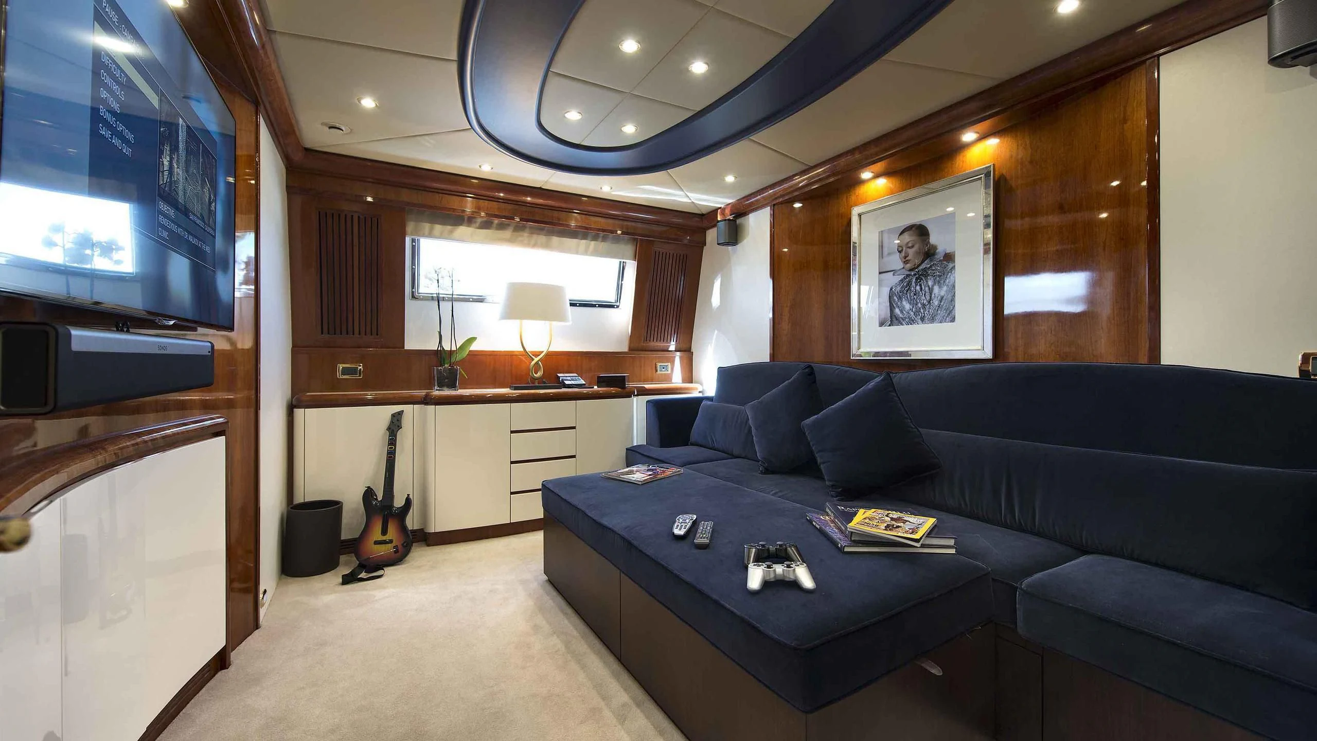 a living room with a blue couch aboard LUMINOUS Yacht for Sale