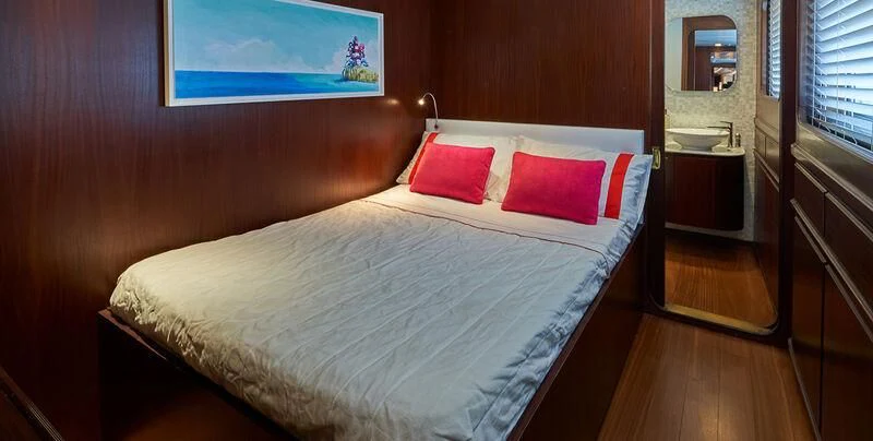 a bed with red pillows aboard DENEB'S DAUGHTERS Yacht for Sale