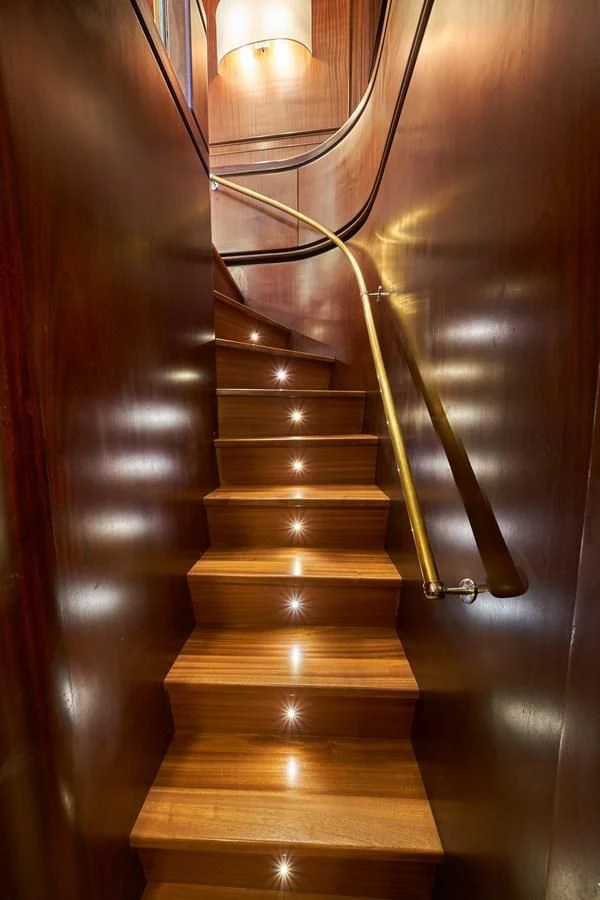 a wooden staircase with a light fixture aboard DENEB'S DAUGHTERS Yacht for Sale