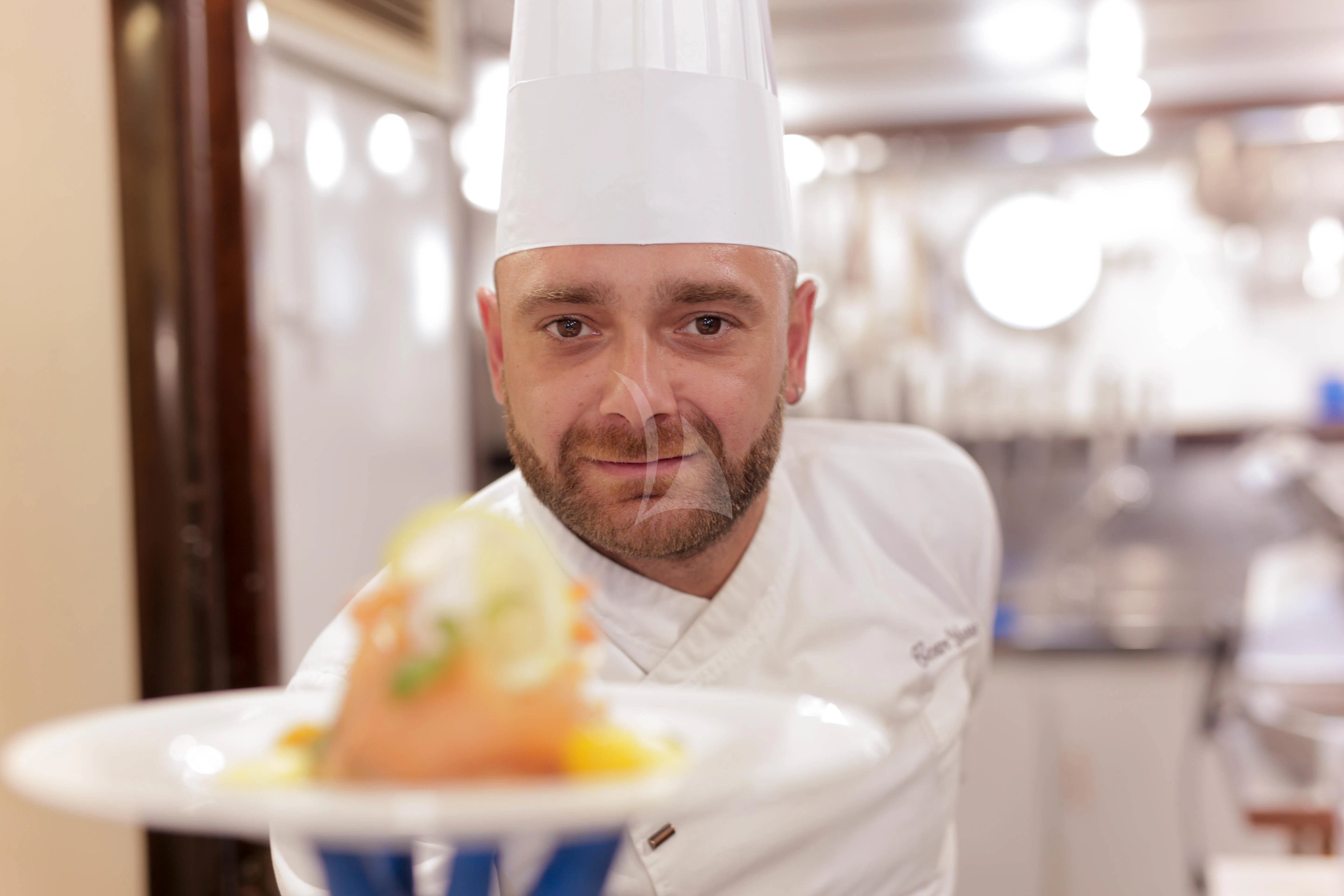 a man holding a plate of food aboard DENEB'S DAUGHTERS Yacht for Sale