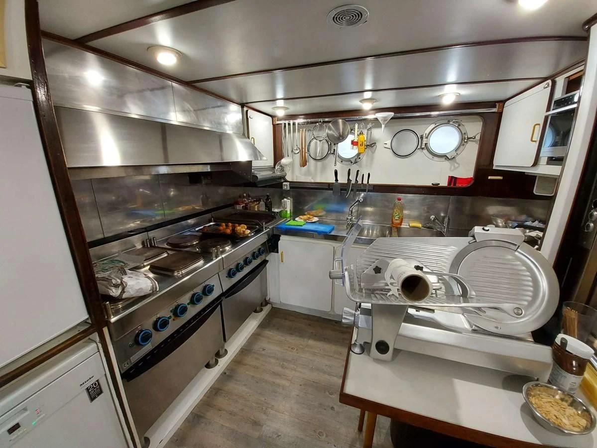 a kitchen with a stove and oven aboard DENEB'S DAUGHTERS Yacht for Sale