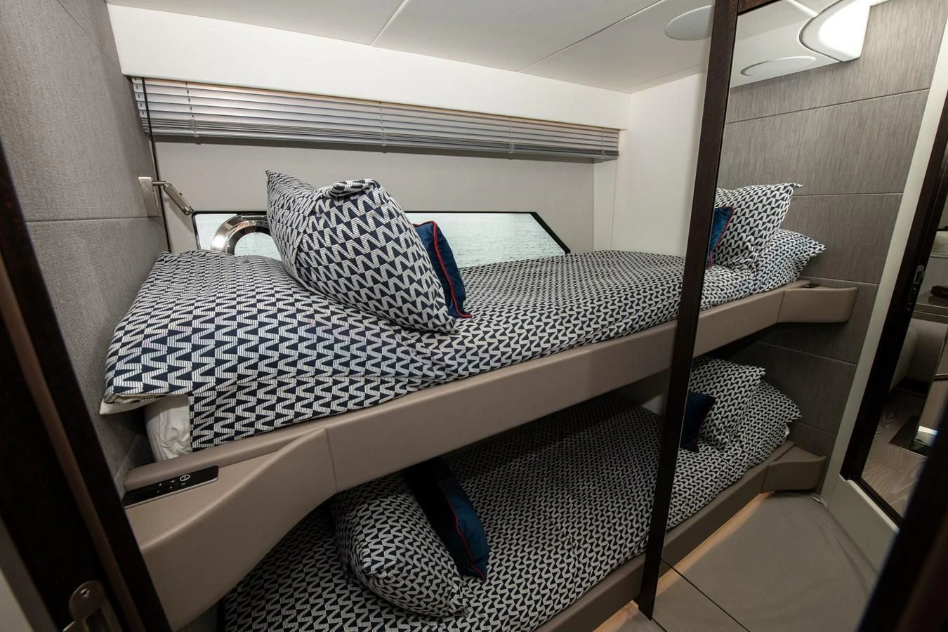 a bed with a blue and white striped pillow aboard INCENTIVIZED Yacht for Sale