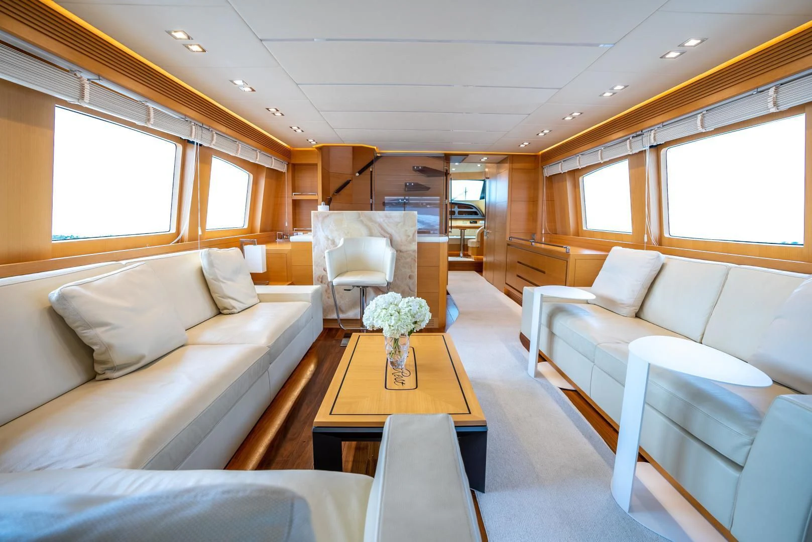 a living room with a table and couches aboard NEVER REST Yacht for Sale