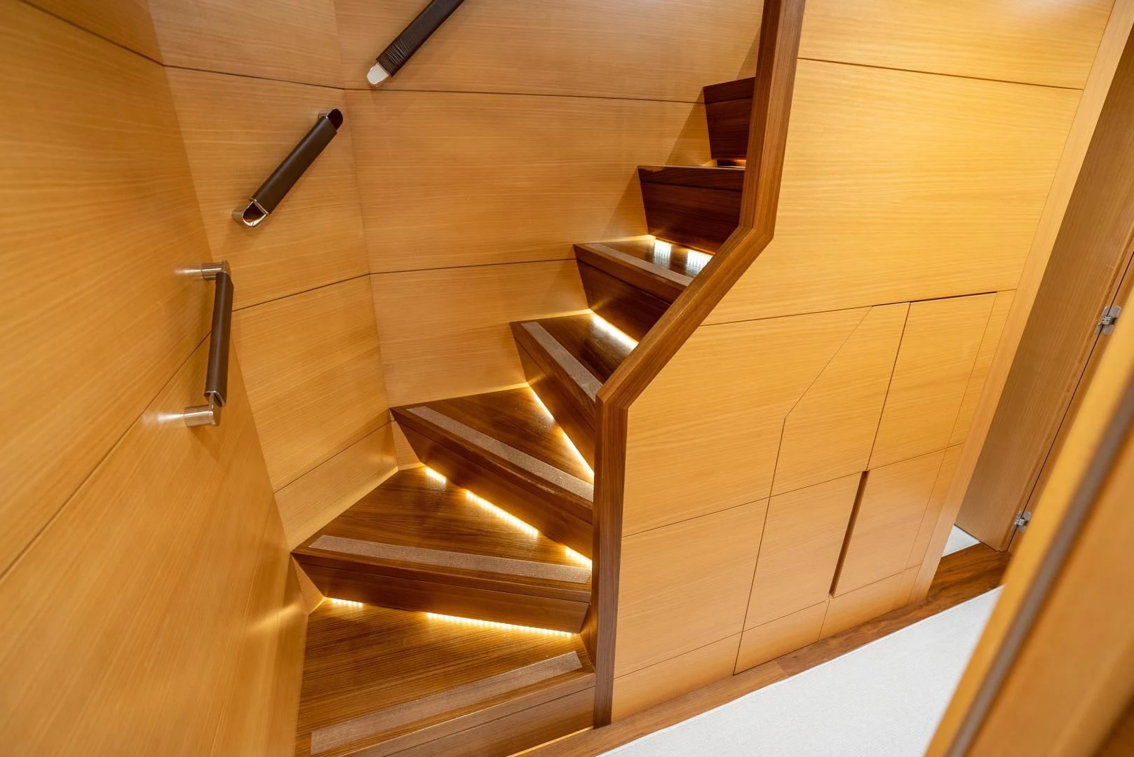 a wooden staircase with a glass railing aboard NEVER REST Yacht for Sale