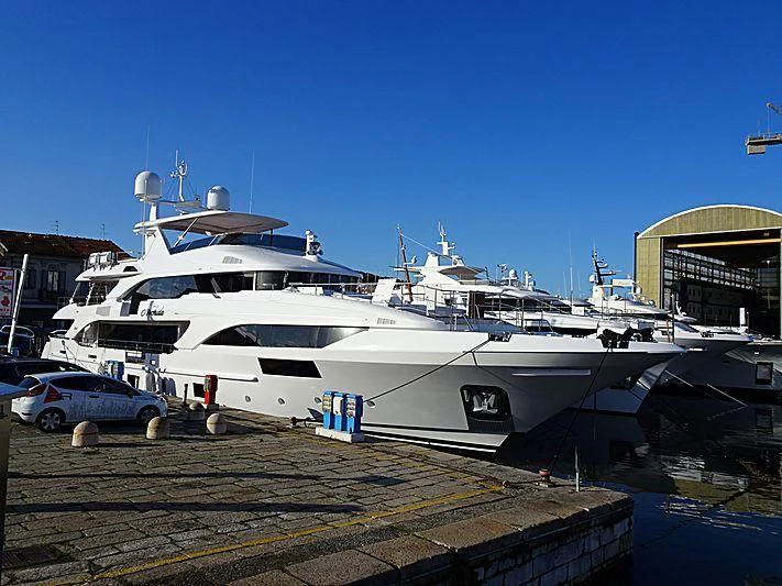 a white yacht docked at a pier aboard NECHIDA Yacht for Sale
