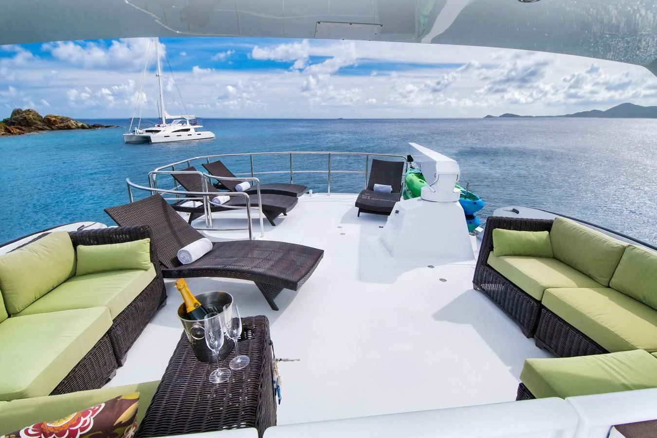 a deck with chairs and a table on it by the water aboard THREE KINGS Yacht for Sale