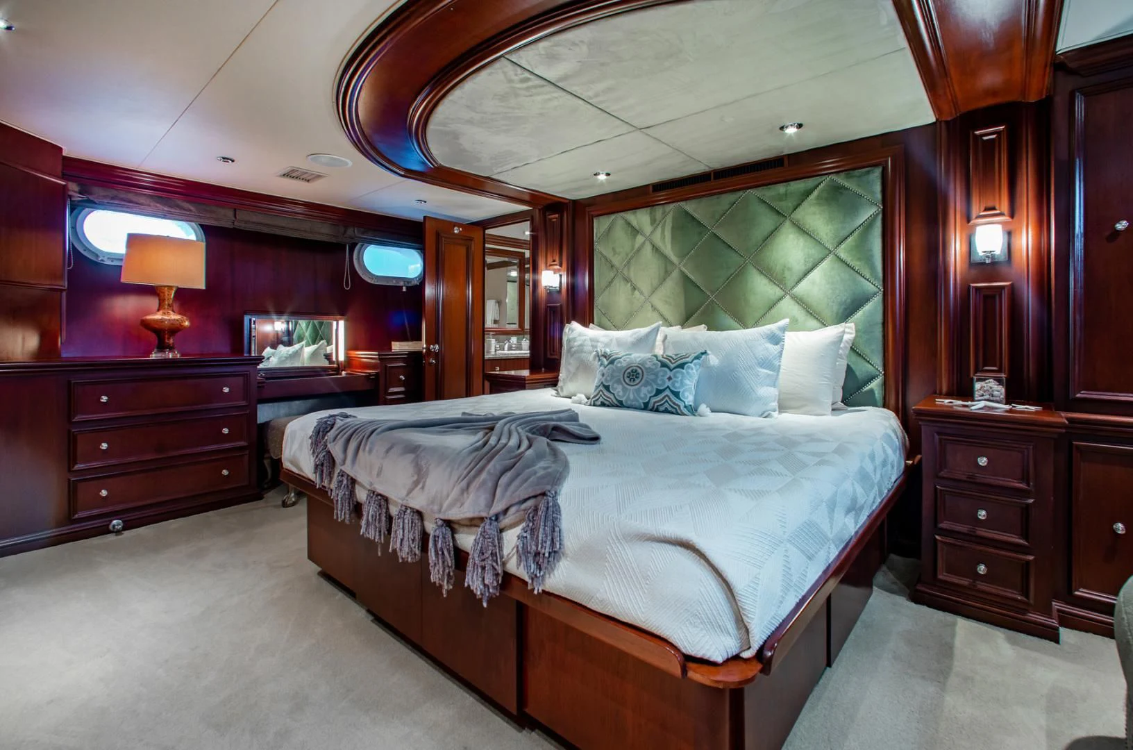 a bedroom with a bed and a large mirror aboard THREE KINGS Yacht for Sale