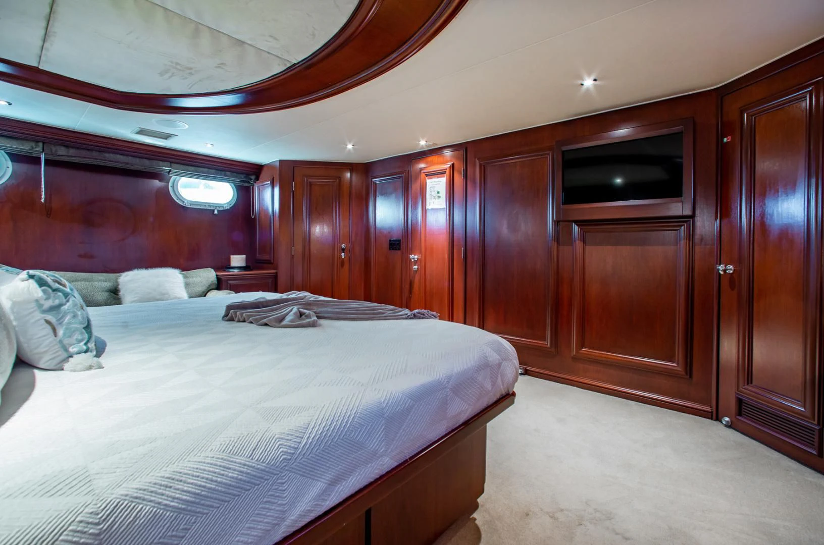 a room with a bed and a wood cabinet aboard THREE KINGS Yacht for Sale