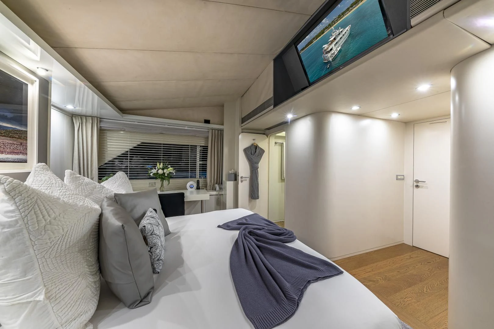 a bed with pillows and a tv above it aboard KARTAL YUVASI Yacht for Charter