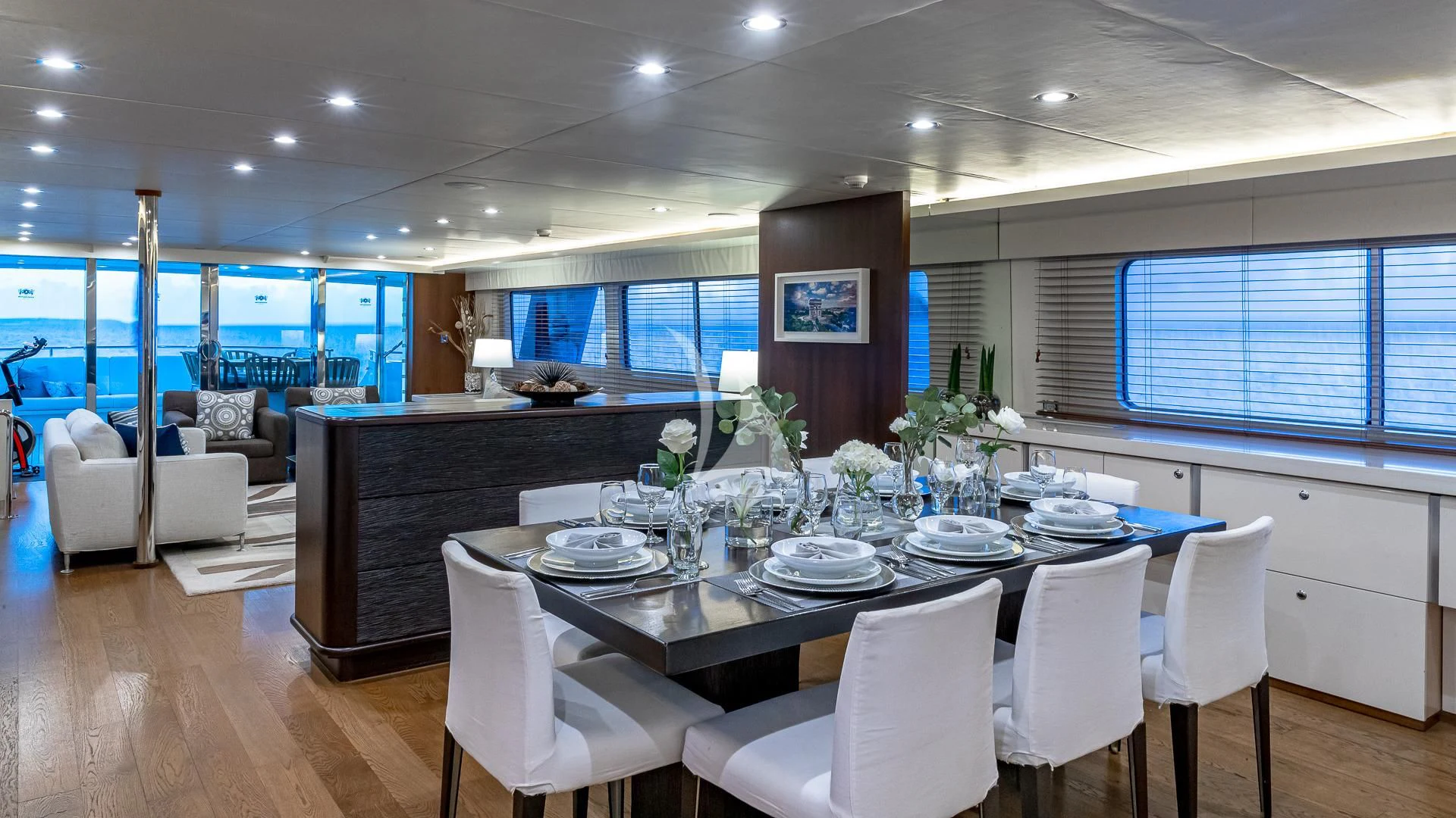 a large dining table with white chairs aboard KARTAL YUVASI Yacht for Charter