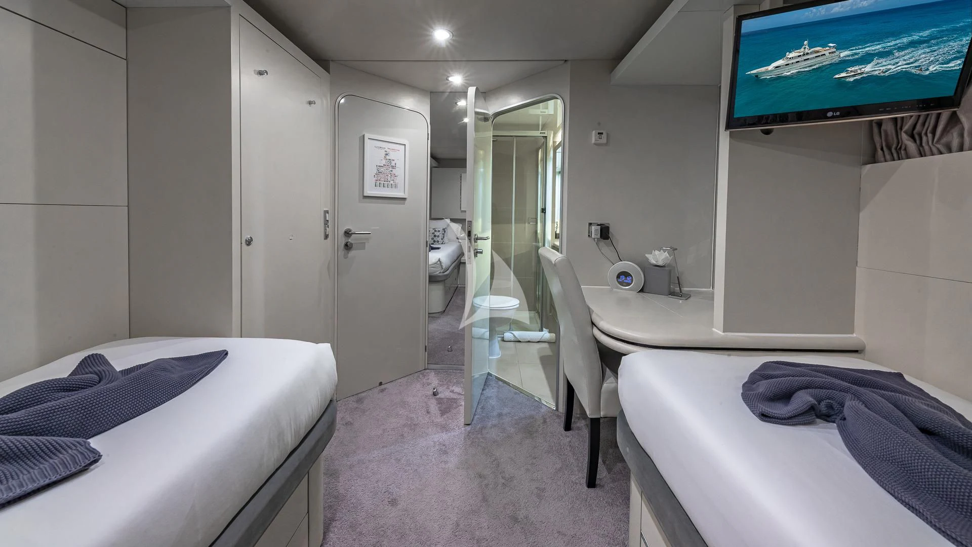 a room with beds and a tv aboard KARTAL YUVASI Yacht for Charter