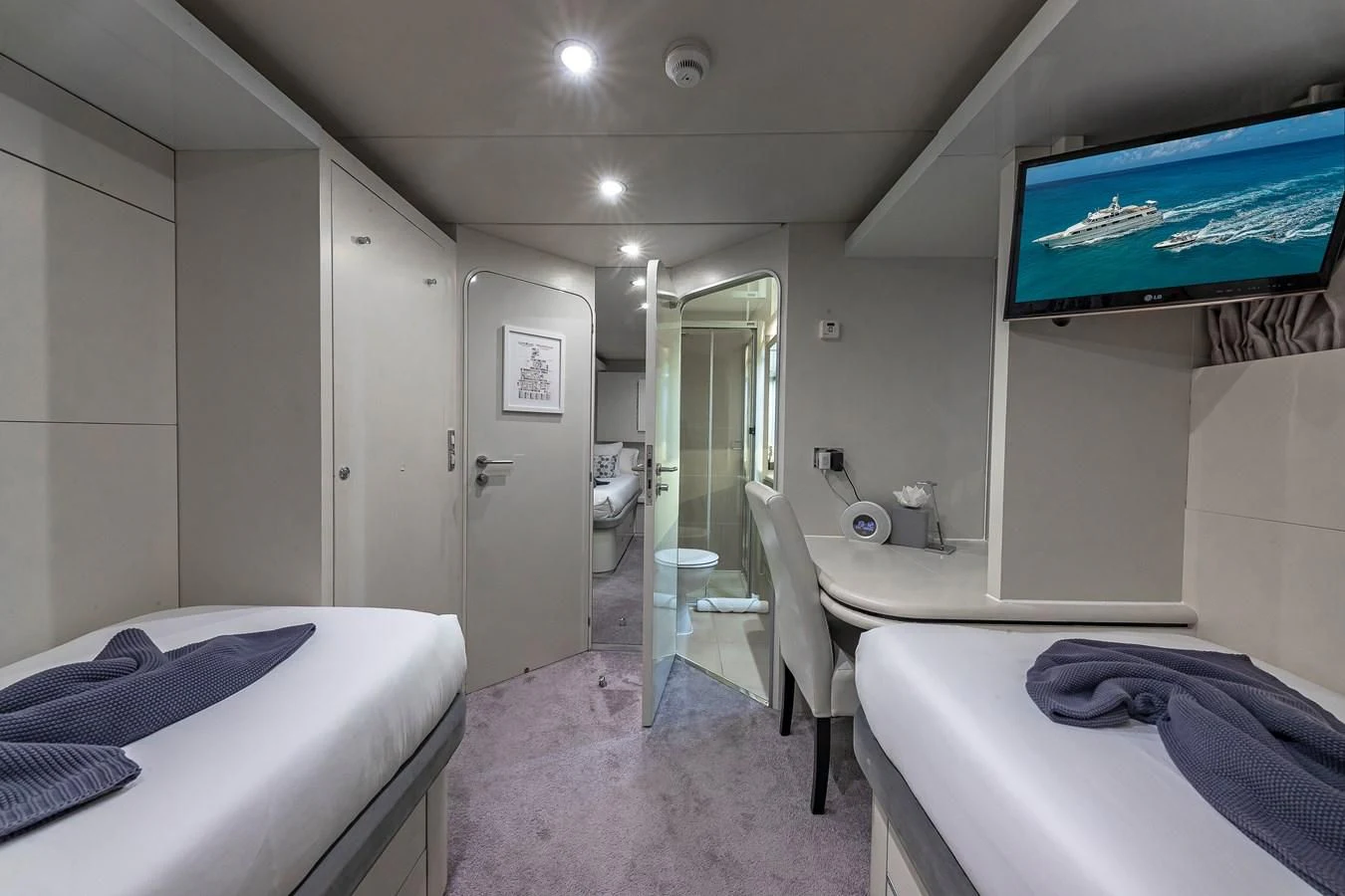 a room with a bed and a tv on the wall aboard KARTAL YUVASI Yacht for Charter