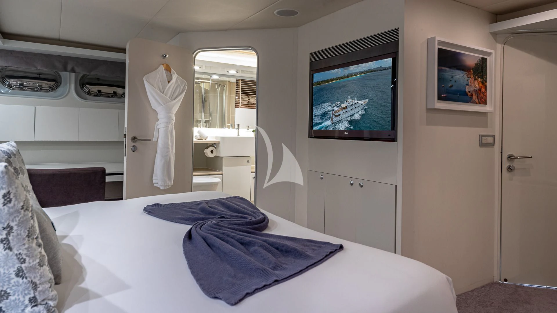 a bedroom with a bed and a television on the wall aboard KARTAL YUVASI Yacht for Charter