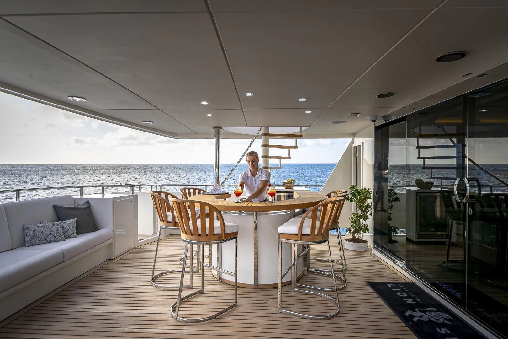 a person sitting at a table in a room with a large body of water aboard KARTAL YUVASI Yacht for Charter