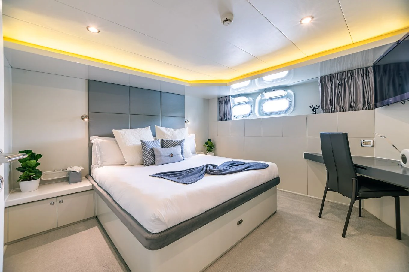 a bedroom with a bed and a chair aboard KARTAL YUVASI Yacht for Charter