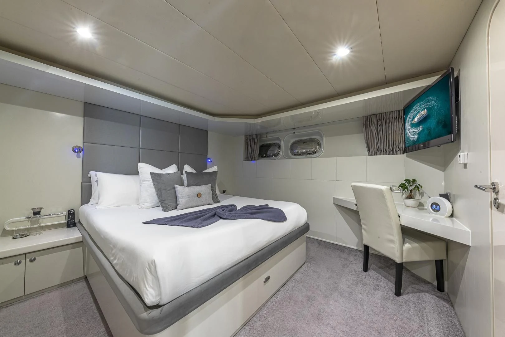 a bedroom with a bed and a tv on the wall aboard KARTAL YUVASI Yacht for Charter