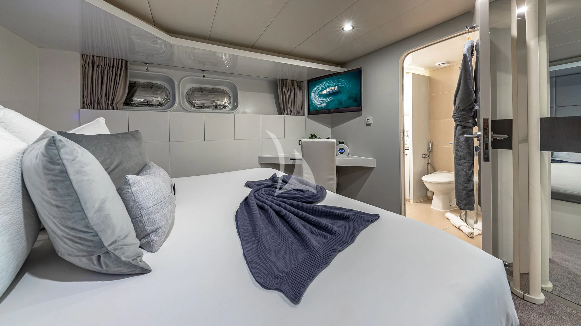 a bed with a blue blanket aboard KARTAL YUVASI Yacht for Charter