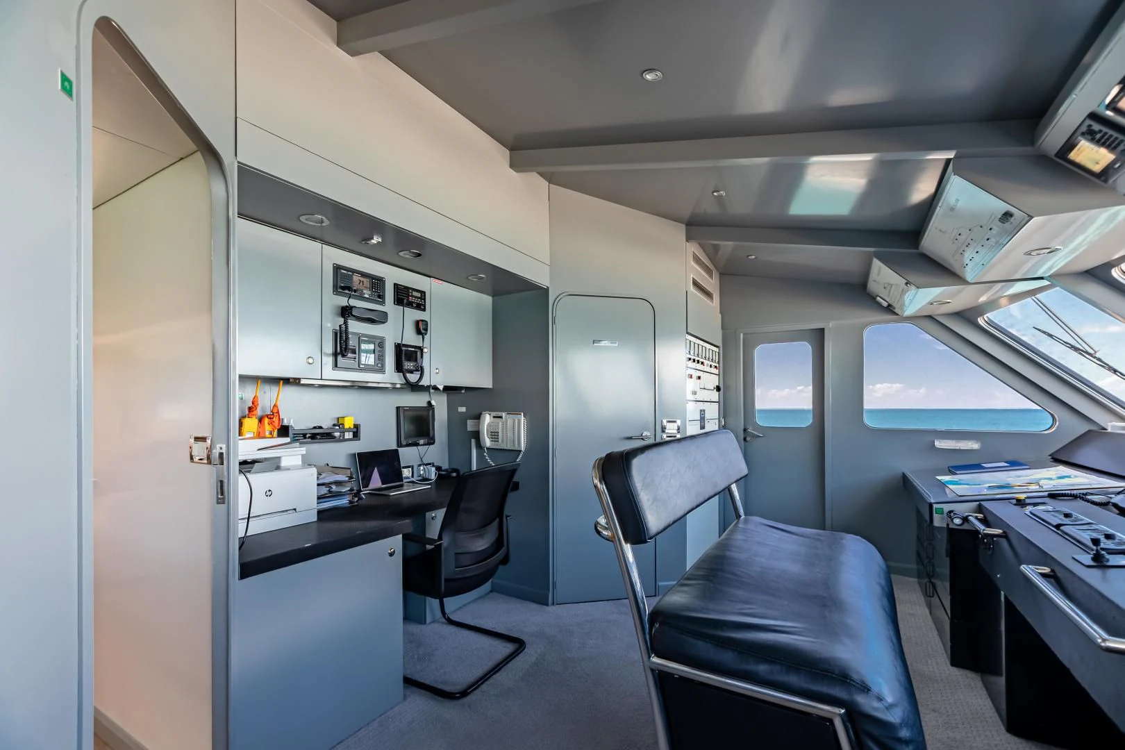 a room with a desk and chairs aboard KARTAL YUVASI Yacht for Charter