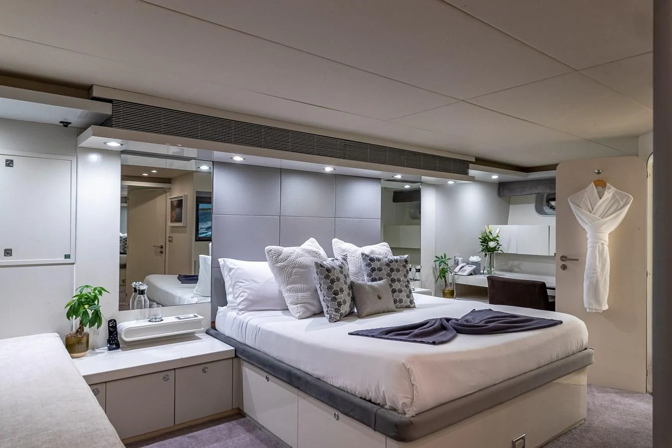a large white bedroom with a large bed and a large mirror aboard KARTAL YUVASI Yacht for Charter