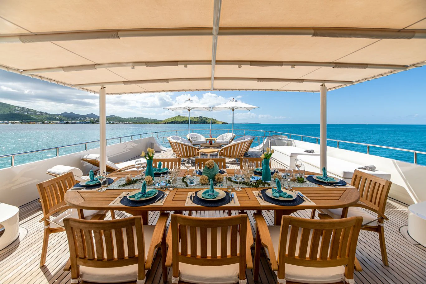 a table set for a meal on a deck overlooking the ocean aboard KARTAL YUVASI Yacht for Charter