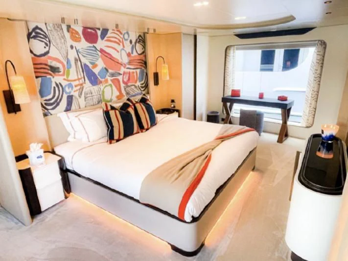 a bedroom with a bed and a table aboard PENJA Yacht for Sale