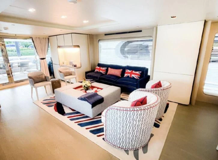 a living room with a blue couch and a white rug aboard PENJA Yacht for Sale