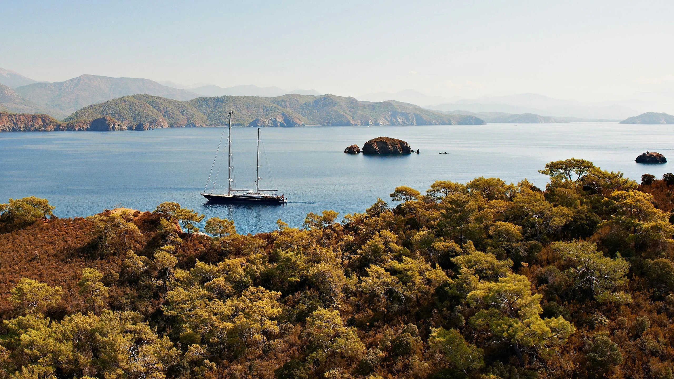 a body of water with a boat in it and a hill in the background aboard MELEK Yacht for Sale