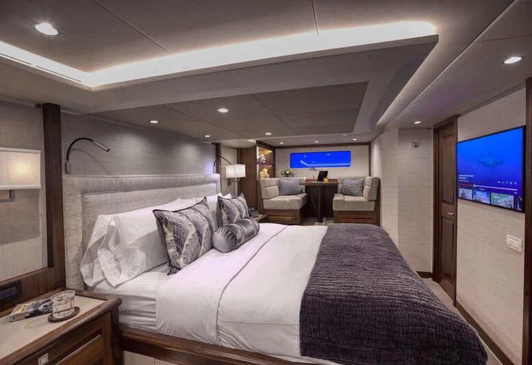 a bed with a television on the wall aboard NEW JOURNEY Yacht for Sale