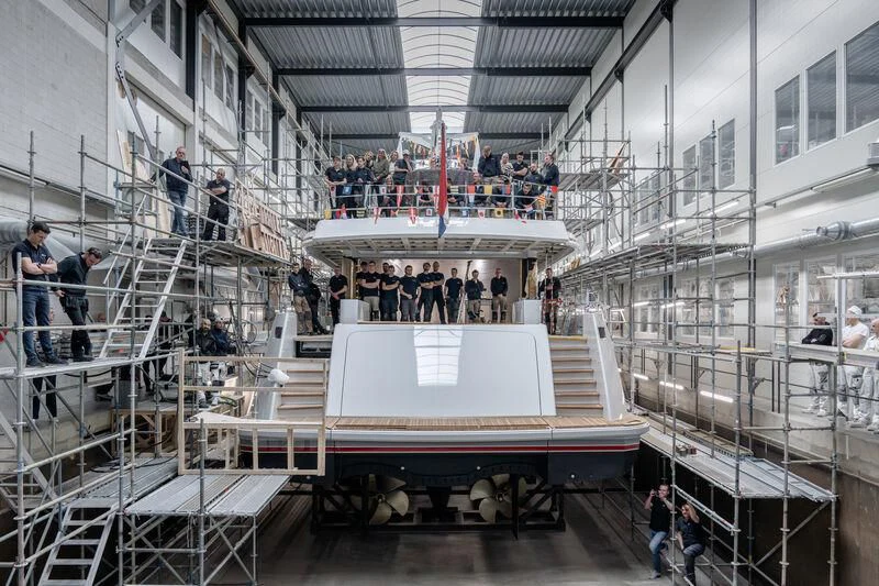 a group of people standing on a staircase with a large white cake on top of it aboard SEAFLOWER Yacht for Sale