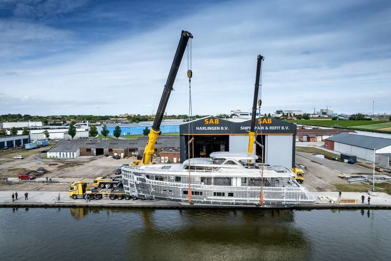 a large white boat with a crane on a dock by a body of water aboard SEAFLOWER Yacht for Sale
