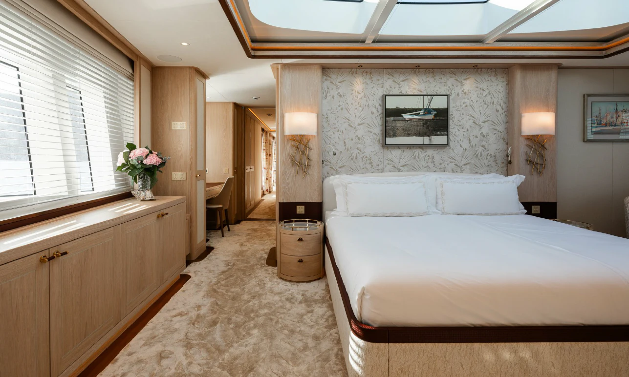 a bedroom with a bed and a desk aboard SEAFLOWER Yacht for Sale
