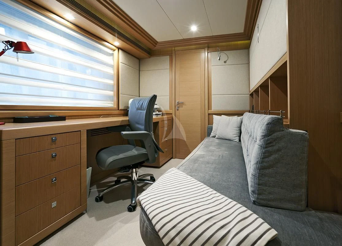a bedroom with a bed and desk aboard LA PAUSA Yacht for Sale