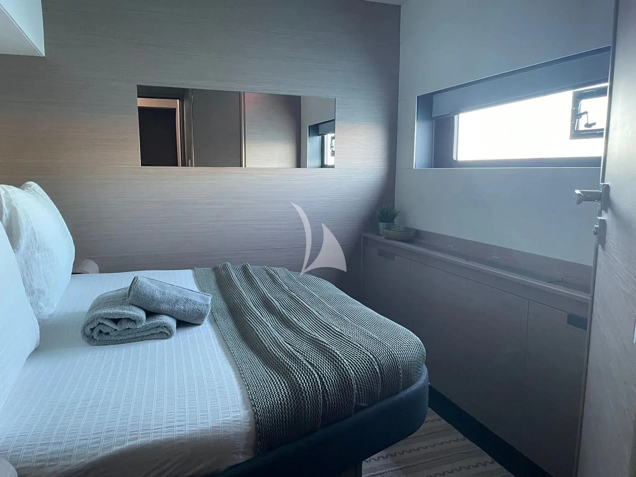 a bed with a white blanket aboard CHILOE Yacht for Charter