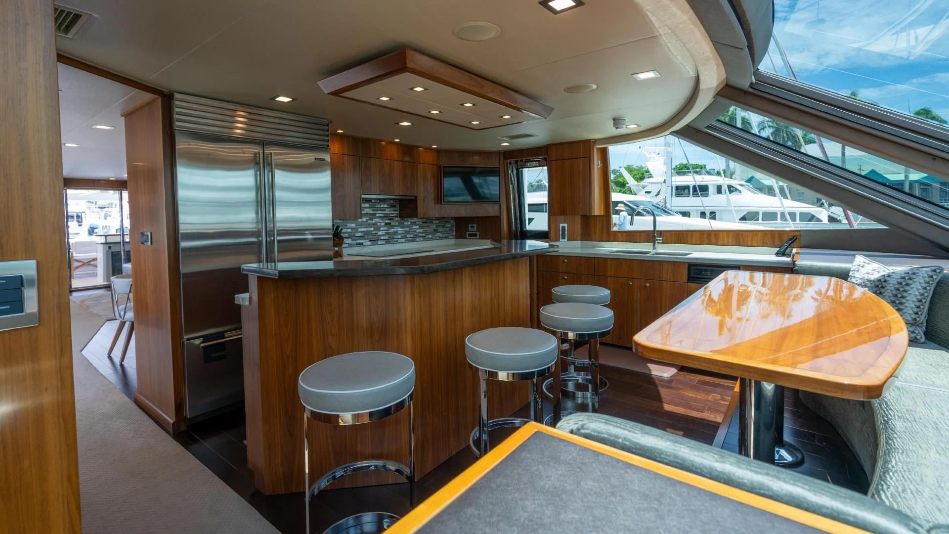 a room with a table and stools and a window aboard OBSESSION Yacht for Sale