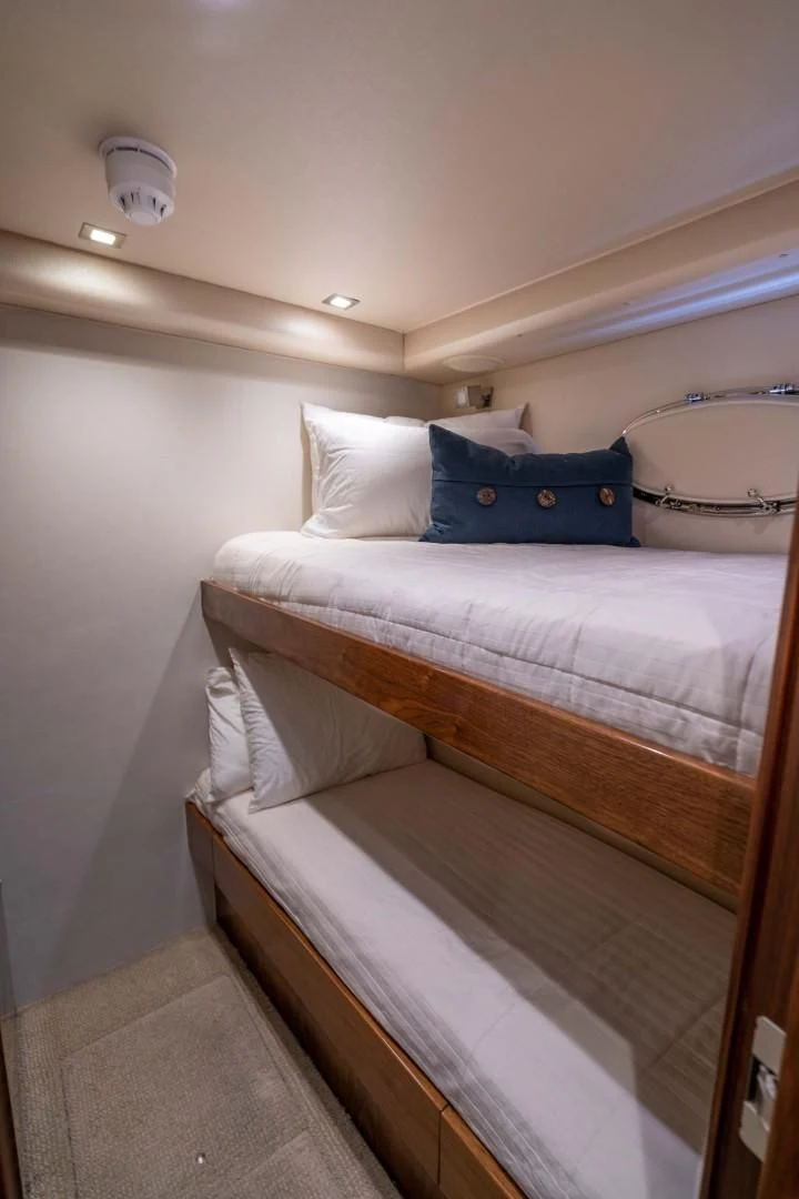 a bed with a blue pillow aboard OBSESSION Yacht for Sale