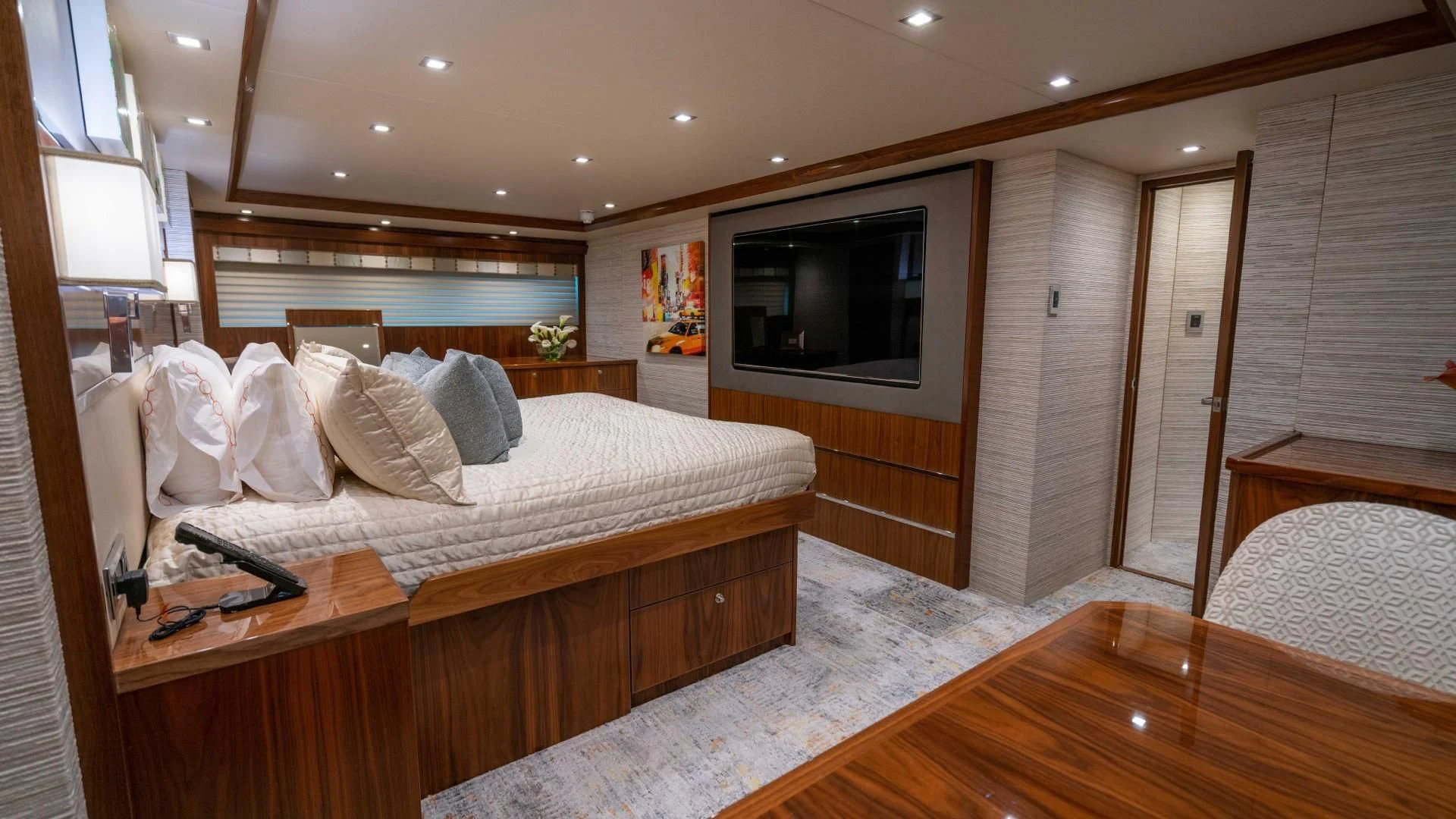a bedroom with a bed and television aboard OBSESSION Yacht for Sale
