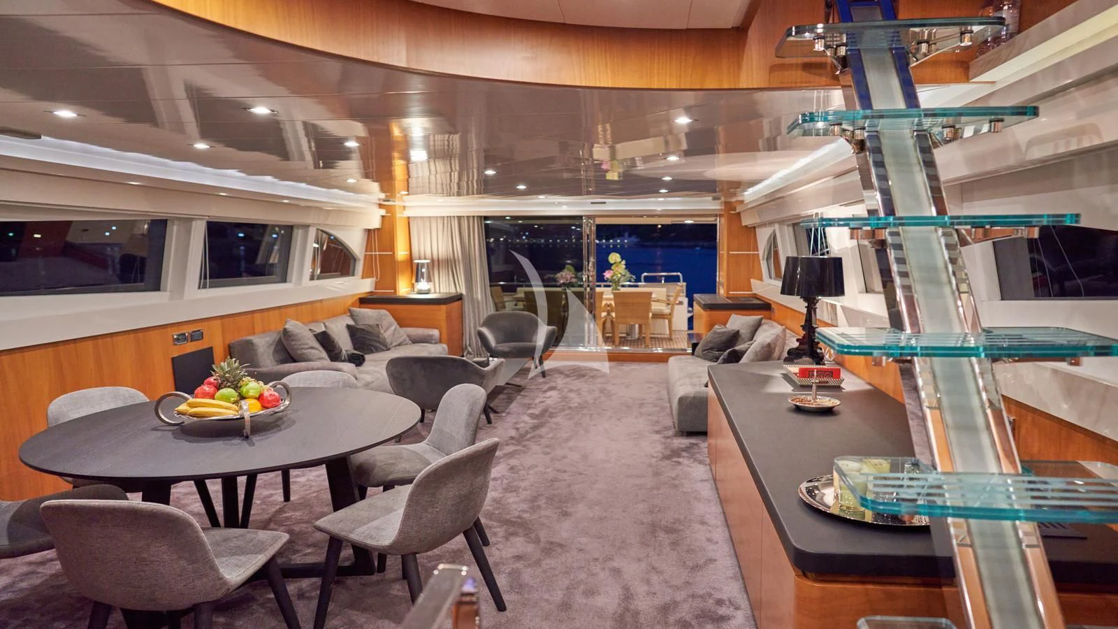 a living room with a glass table and a large glass window aboard KARISMA Yacht for Sale