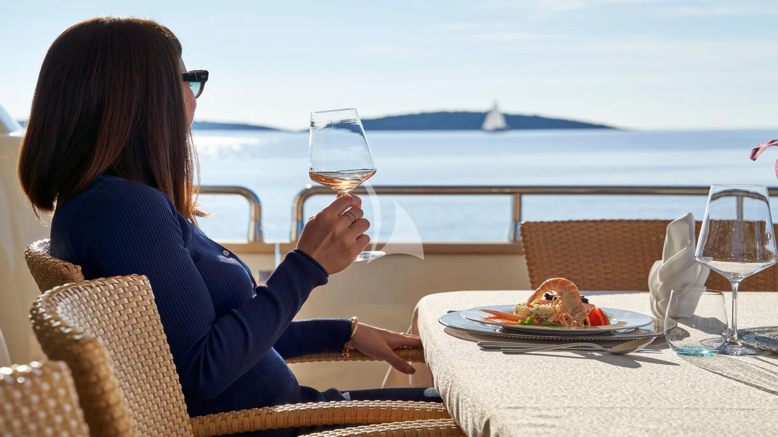 a woman sitting at a table with a glass of wine aboard KARISMA Yacht for Sale