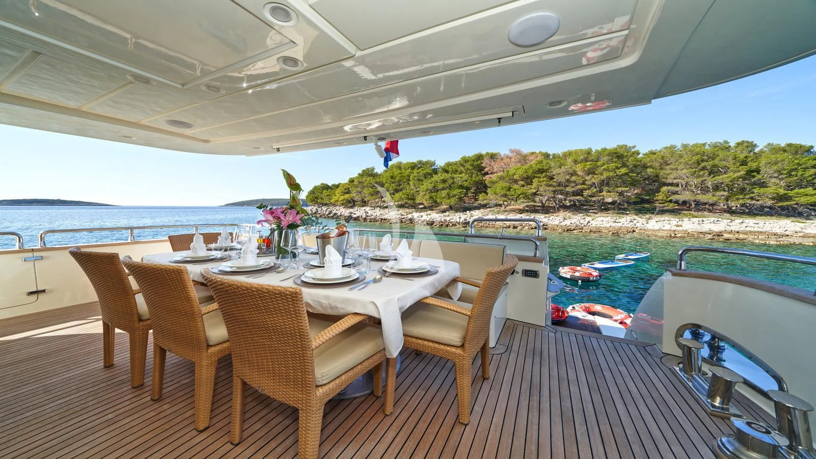 a table set for a meal on a deck overlooking a lake aboard KARISMA Yacht for Sale