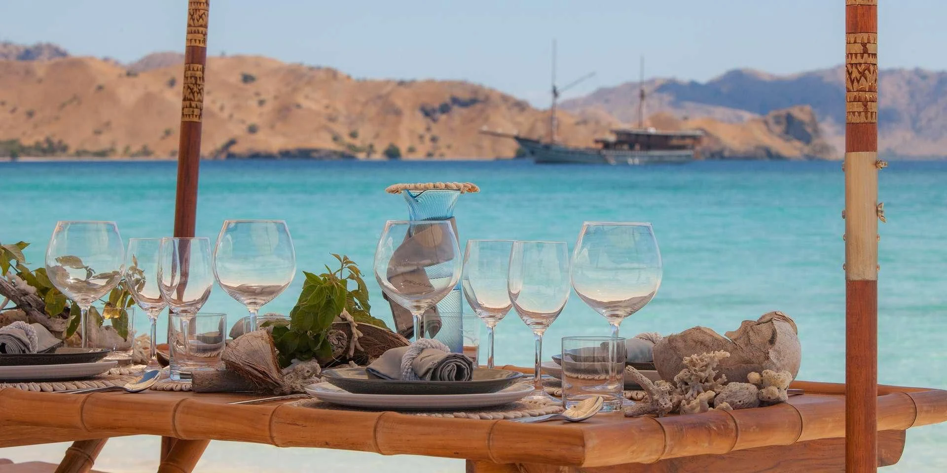 a table with wine glasses and food on it aboard PRANA Yacht for Charter