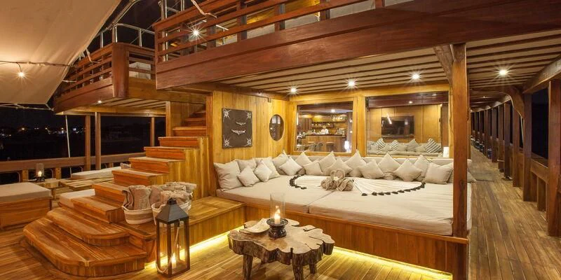 a large room with a bed and a table aboard PRANA Yacht for Charter